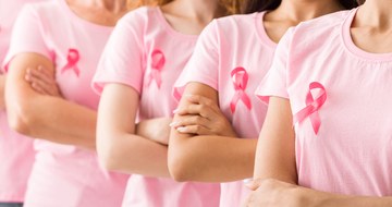 A line of women with breast cancer ribbons on their chests